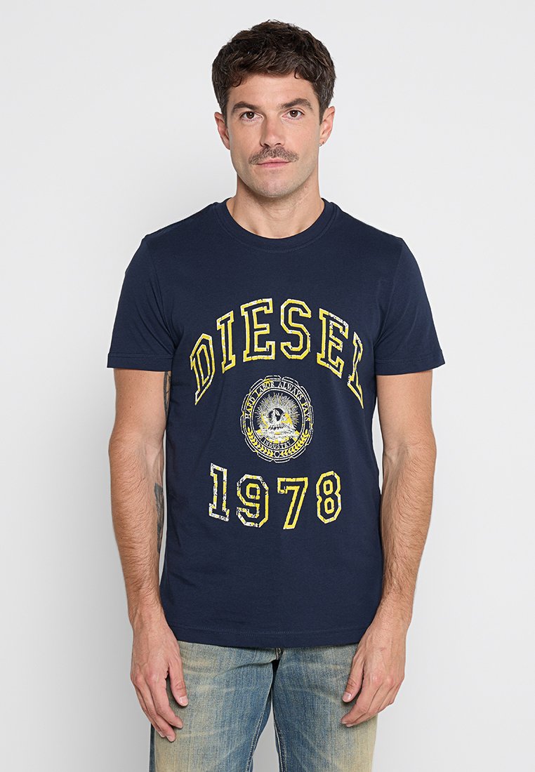 Navyblaues Baumwoll-T-Shirt mit gelbem Grafikdruck, auf dem "DIESEL 1978" steht. Mit Rundhalsausschnitt und kurzen Ärmeln.