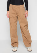 Beige weite Hosen aus Baumwolle mit hoher Taille, Falten und lockerer Passform. Kombiniert mit hellen Sneakers.