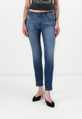 Schmale blaue Jeans mit mittelhohem Bund, klassischem Fünf-Taschen-Design und leichter Ausbleichung. Getragen mit schwarzen spitzen Absätzen.