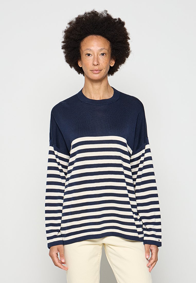 Gestreifter Pullover in Marineblau und Creme mit Rundhalsausschnitt, überschnittenen Schultern und einem lockeren Schnitt. Texturierter Stoff mit einem horizontalen Streifenmuster.