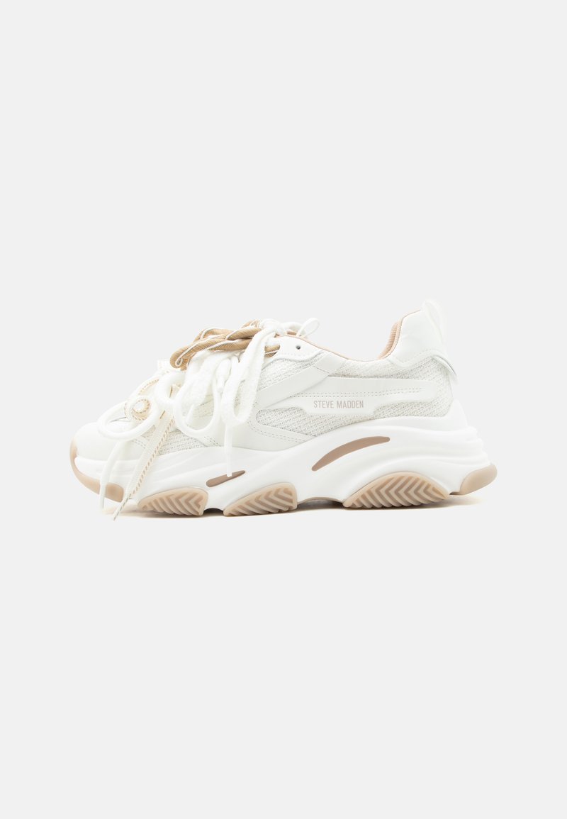 Weißer und beiger Steve Madden Sneaker mit Mesh-Einsätzen, dicker Sohle und doppelten Schnürsenkeln auf hellem einfarbigem Hintergrund.