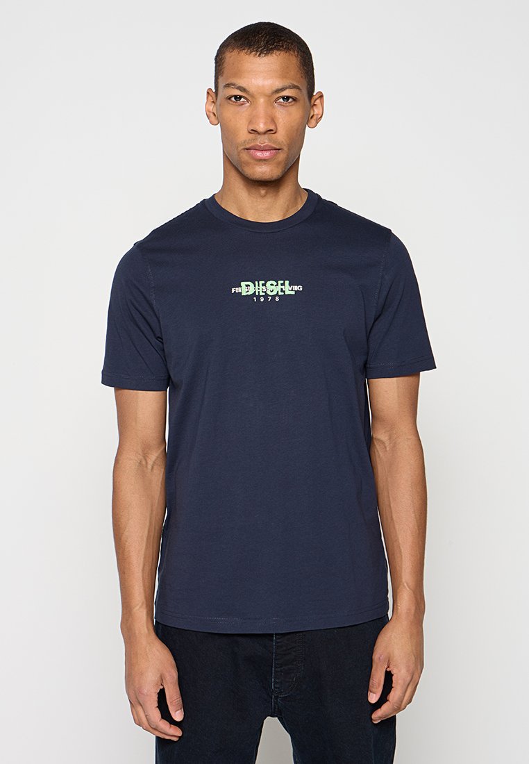 Marineblaues kurzärmeliges T-Shirt aus Baumwolle, mit einem grünen Grafikdruck "DIESEL 1978" auf der Vorderseite, rundem Ausschnitt und normaler Passform.