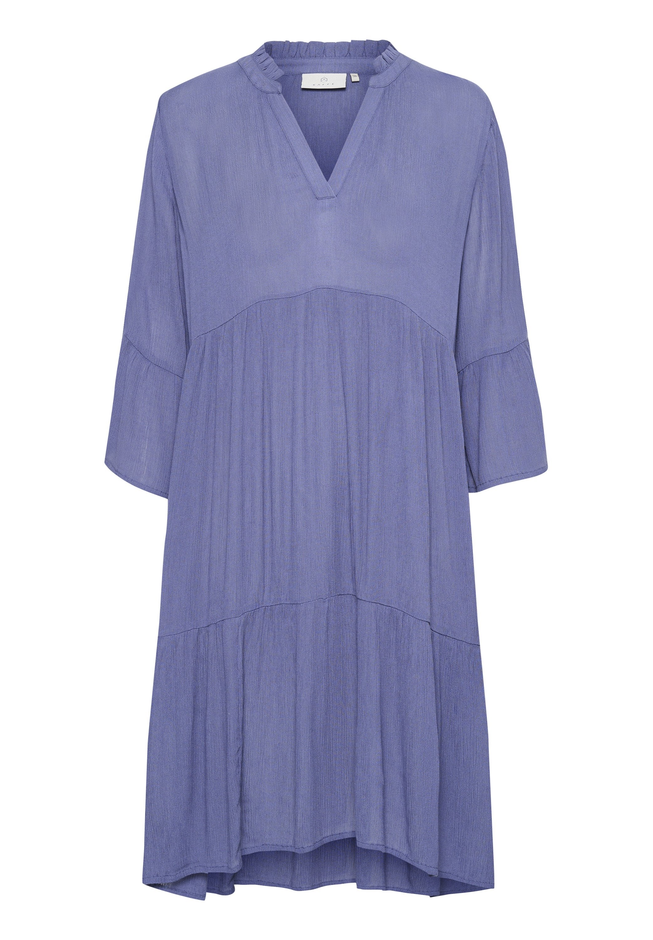 Luftiges, gestuftes Kleid aus helllila Stoff. Mit V-Ausschnitt, Dreiviertelärmeln und einer strukturierten Oberfläche.