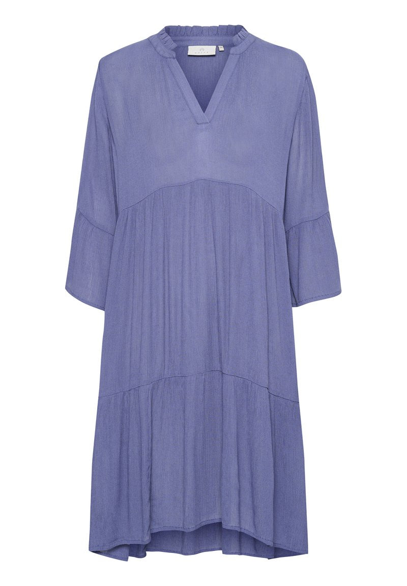 Luftiges, gestuftes Kleid aus helllila Stoff. Mit V-Ausschnitt, Dreiviertelärmeln und einer strukturierten Oberfläche.