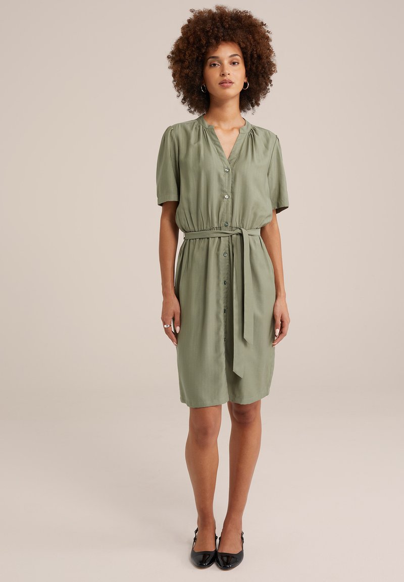 Khakifarbene, kurzärmelige Kleid mit durchgehender Knopfleiste, taillierter Taille und gebundenem Gürtel. Glatte Textur mit entspannter Silhouette.