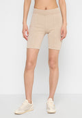 Beige Radshorts mit hohem Taillenbund, elastischem Baumwollmaterial, kontrastierenden Nähten und figurbetontem Schnitt, kombiniert mit hellen Sneakers.