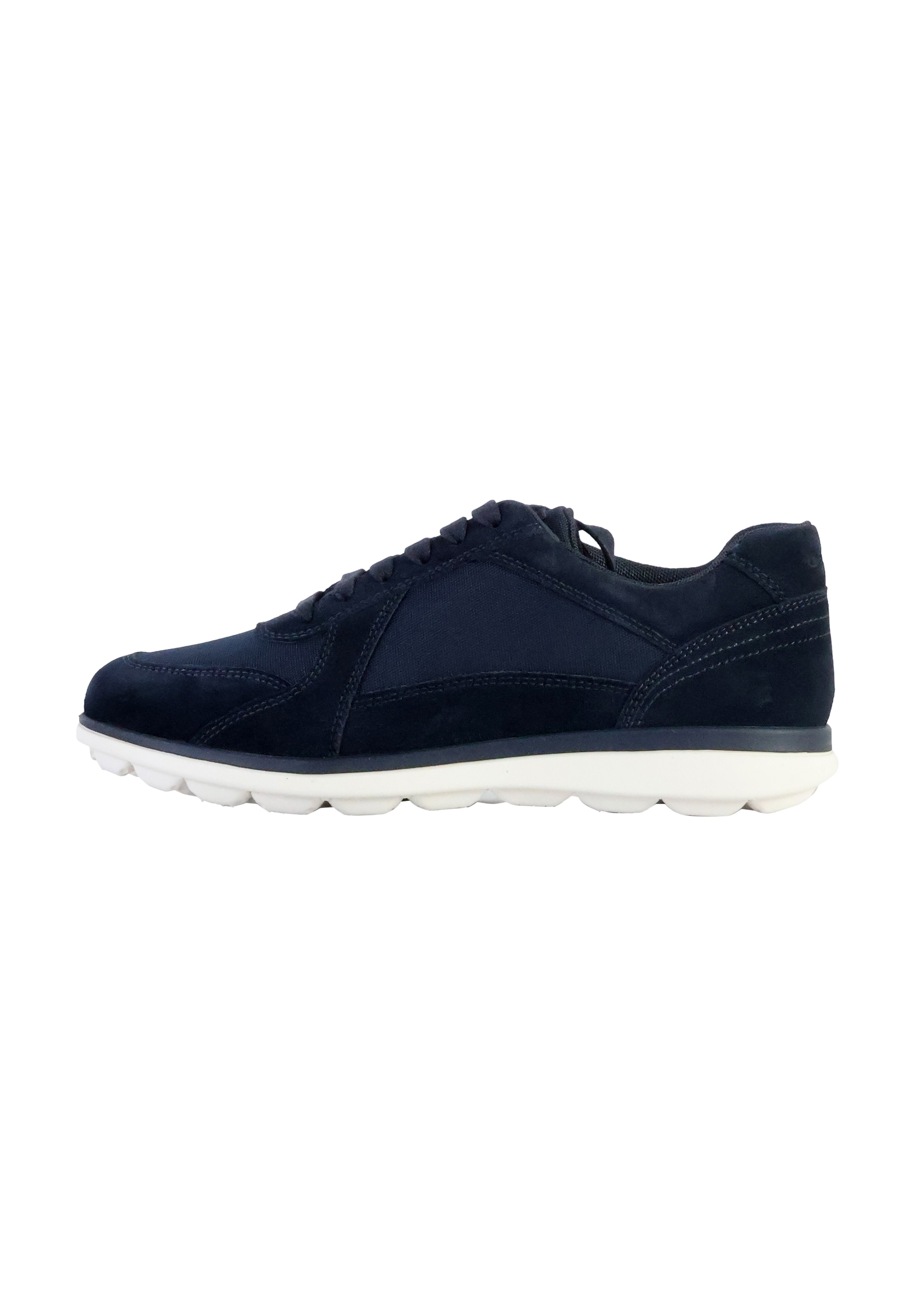 Marineblaue Sportschuhe mit einem Obermaterial aus Wildleder und Stoff, runder Zehenbereich, weißer Gummisohle mit deutlich abgerundeten Segmenten und Schnürdesign.