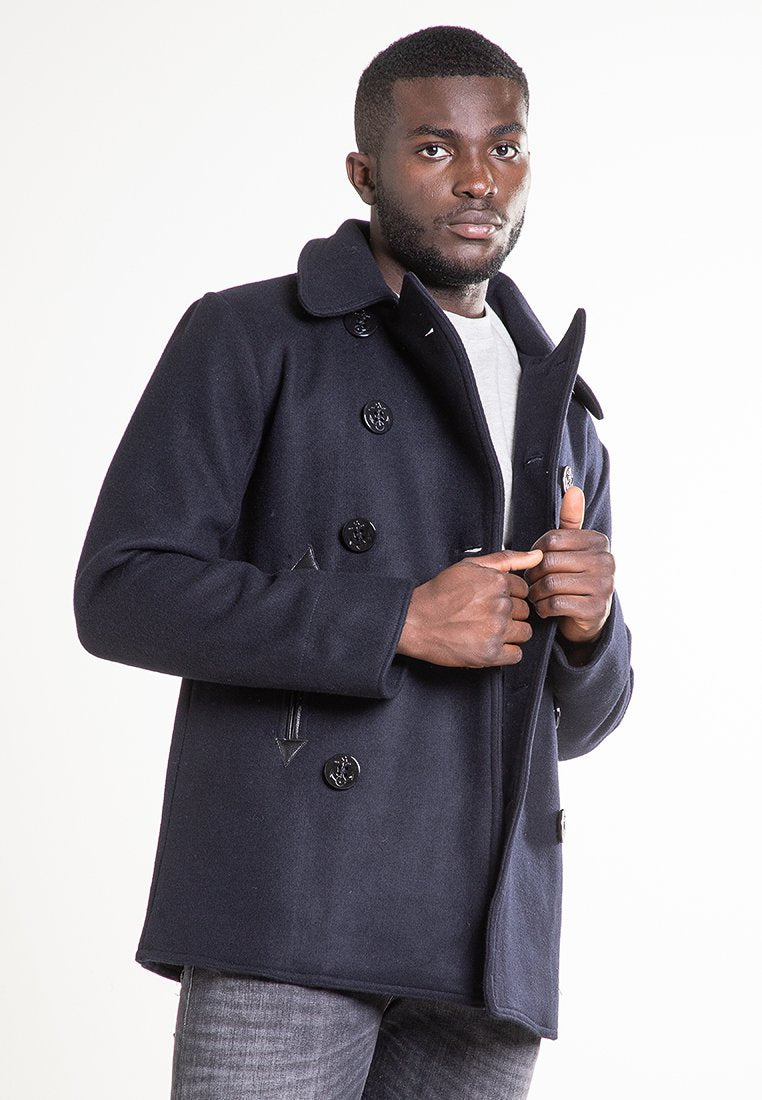 Marineblauer Woll-Peacoat mit doppeltknöpfem Front, großen schwarzen Knöpfen, breitem Kragen und Seitentaschen; strukturierter Stoff mit taillierter Passform.