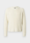 Cremfarbener Strickpullover mit langen Ärmeln, gerippten Bündchen und Saum sowie einem runden Ausschnitt vor einem schlichten weißen Hintergrund.