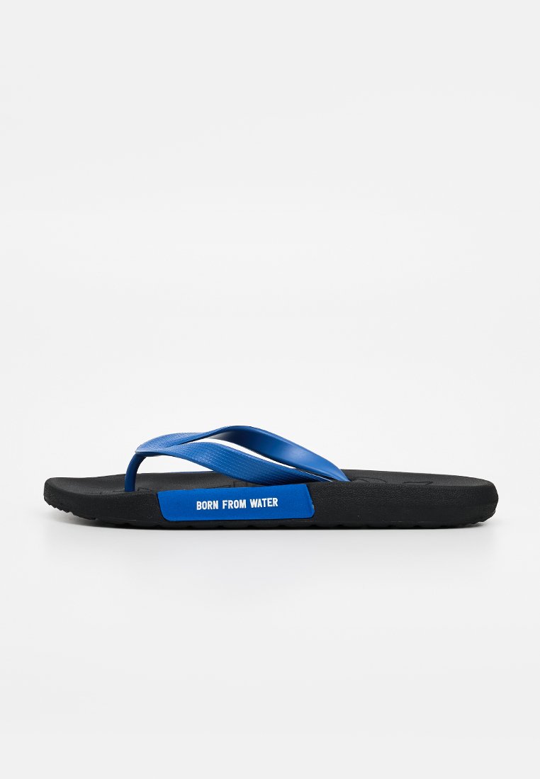 Schwarze Flip-Flop-Sandale mit blauen Riemen und einem "BORN FROM WATER"-Label an der Seite der Sohle, seitlich auf weißem Hintergrund gezeigt.