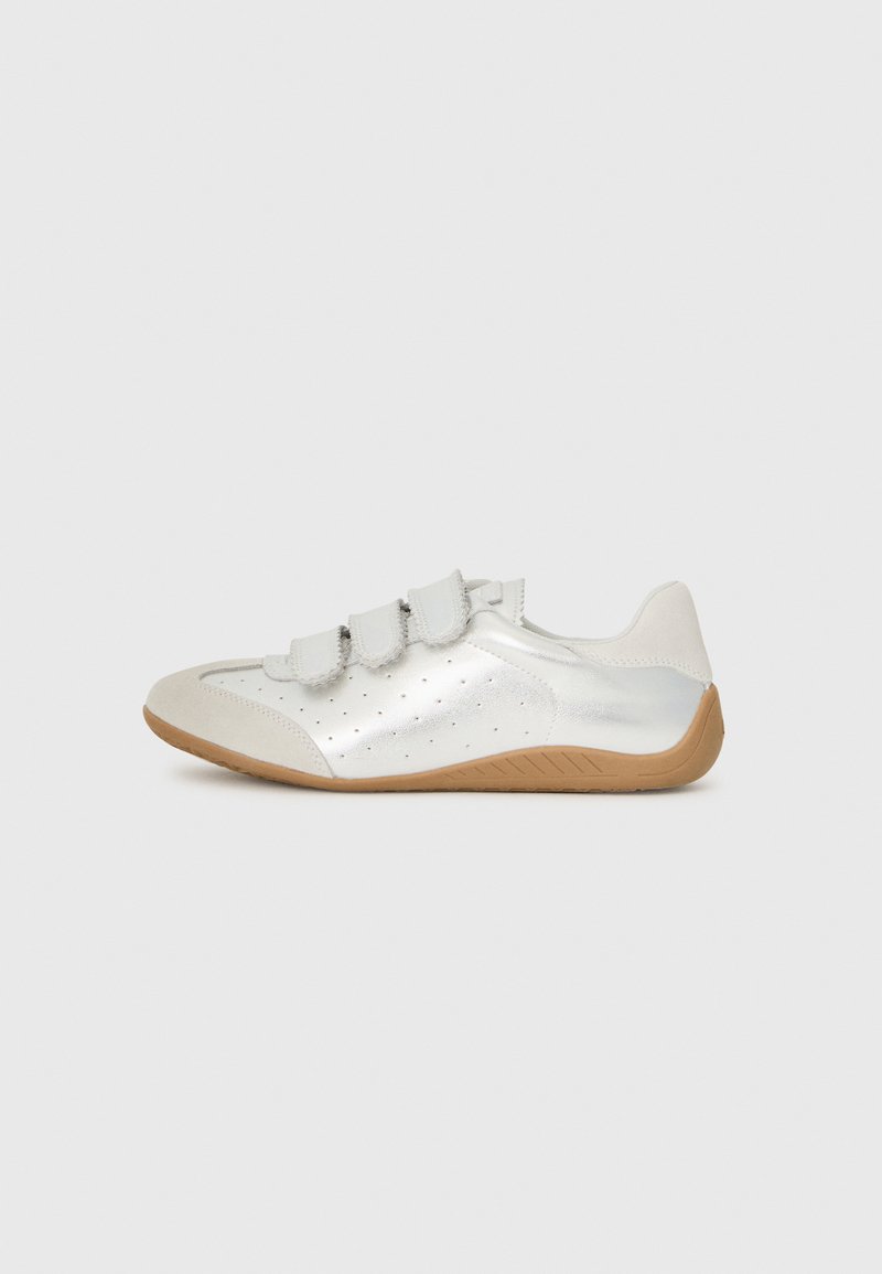 Weißes Leder-Schuhwerk mit metallischem Glanz, drei Klettverschlüssen und einer strukturierten Gummisohle. Verfügt über perforierte Details an der Seite.