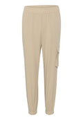 Beige weite Hosen mit elastischem Bund, umgeschlagenen Knöcheln und einer seitlichen Cargo-Tasche. Hergestellt aus leichtem, strukturiertem Stoff.
