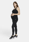 Schwarzes Still-Tanktop und Leggings mit taillierter Passform. Weißes Nike-Logo auf dem Oberteil und den Hosen. Schwarze Sportschuhe mit strukturiertem Absatz.