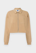 Beige verkürzte Jacke mit dünnen weißen Nadelstreifen, Reißverschluss vorne, zwei Brusttaschen, langen Ärmeln mit elastischen Bündchen und spitzem Kragen.