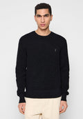 Schwarzer Strickpullover mit langen Ärmeln, rundem Ausschnitt und gerippten Bündchen und Saum. Besonderheit ist ein kleines besticktes Logo auf der Brust.