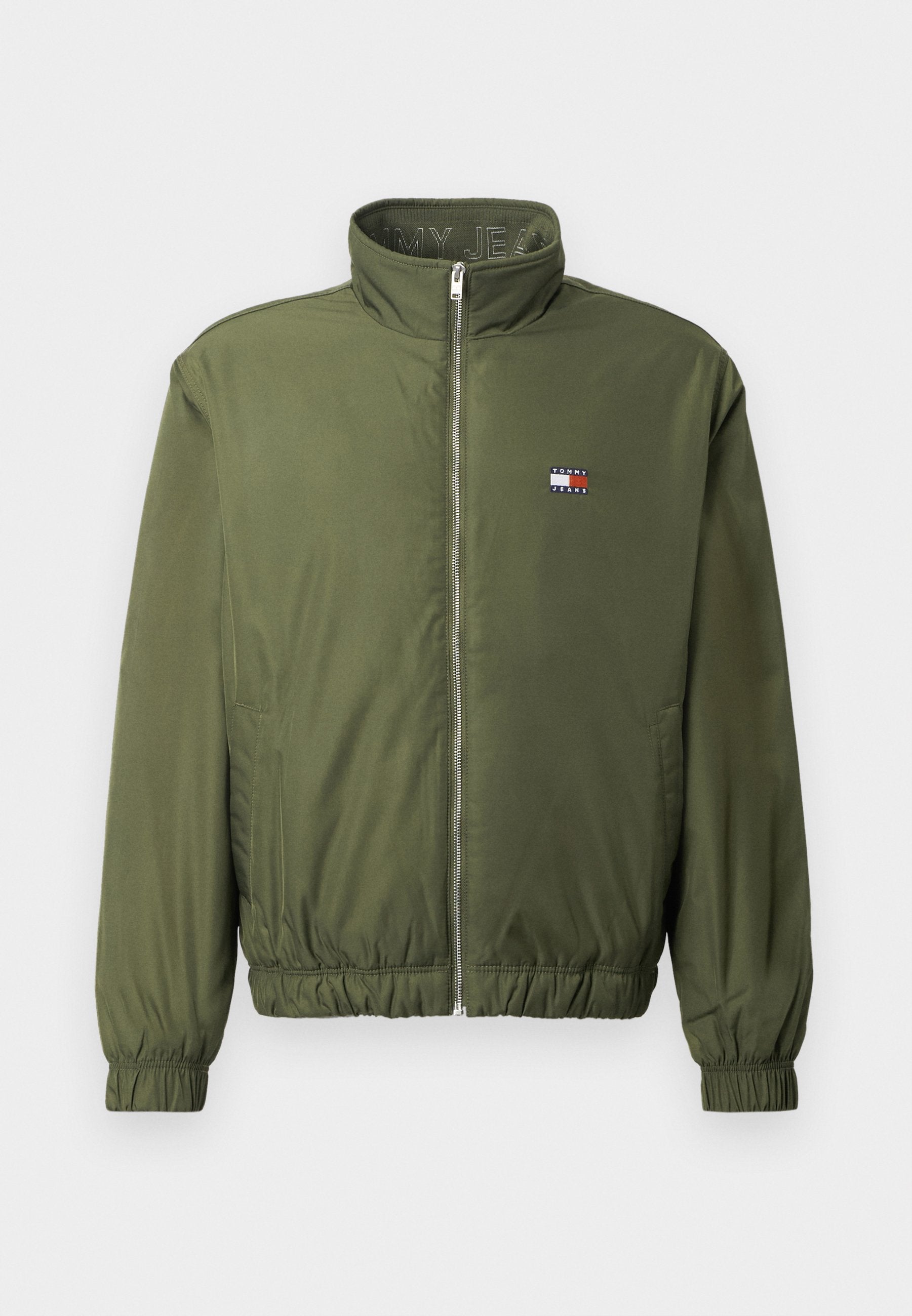 Olivegrüner Bomberjacke mit hohem Kragen, Frontreißverschluss, elastischen Bündchen und Saum. Verfügt über ein kleines Logopatch auf der Brust.