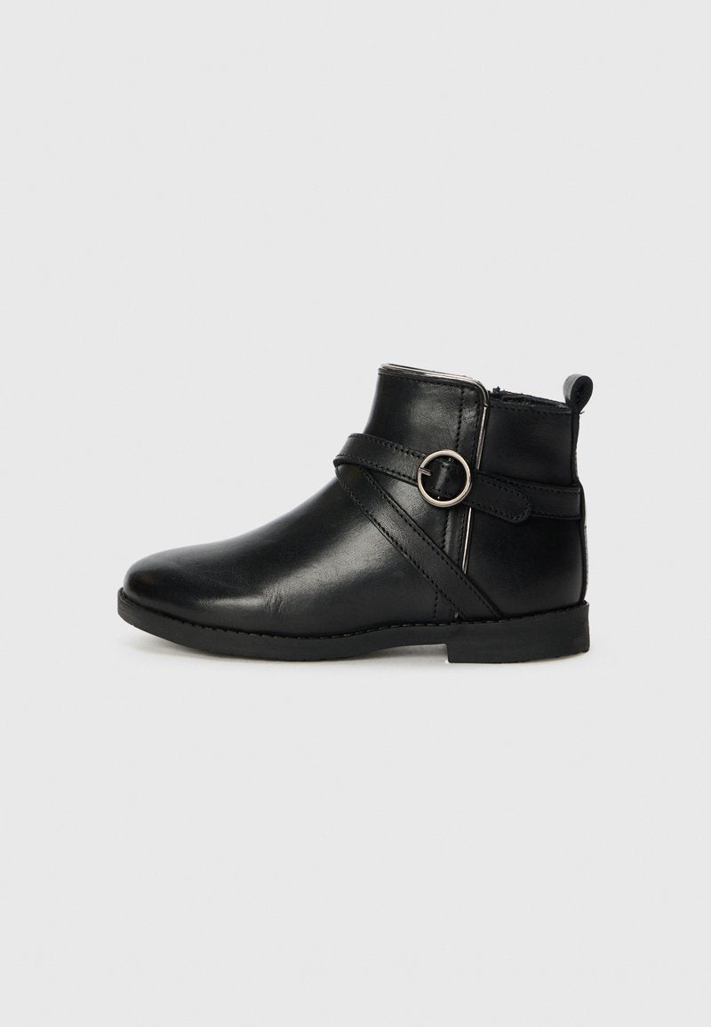 Schwarze Leder-Stiefelette mit abgerundetem Zeh, einem seitlichen Reißverschluss und einem dekorativen Riemen mit einem runden Metallakzent. Flache Sohle und Nähdetails.