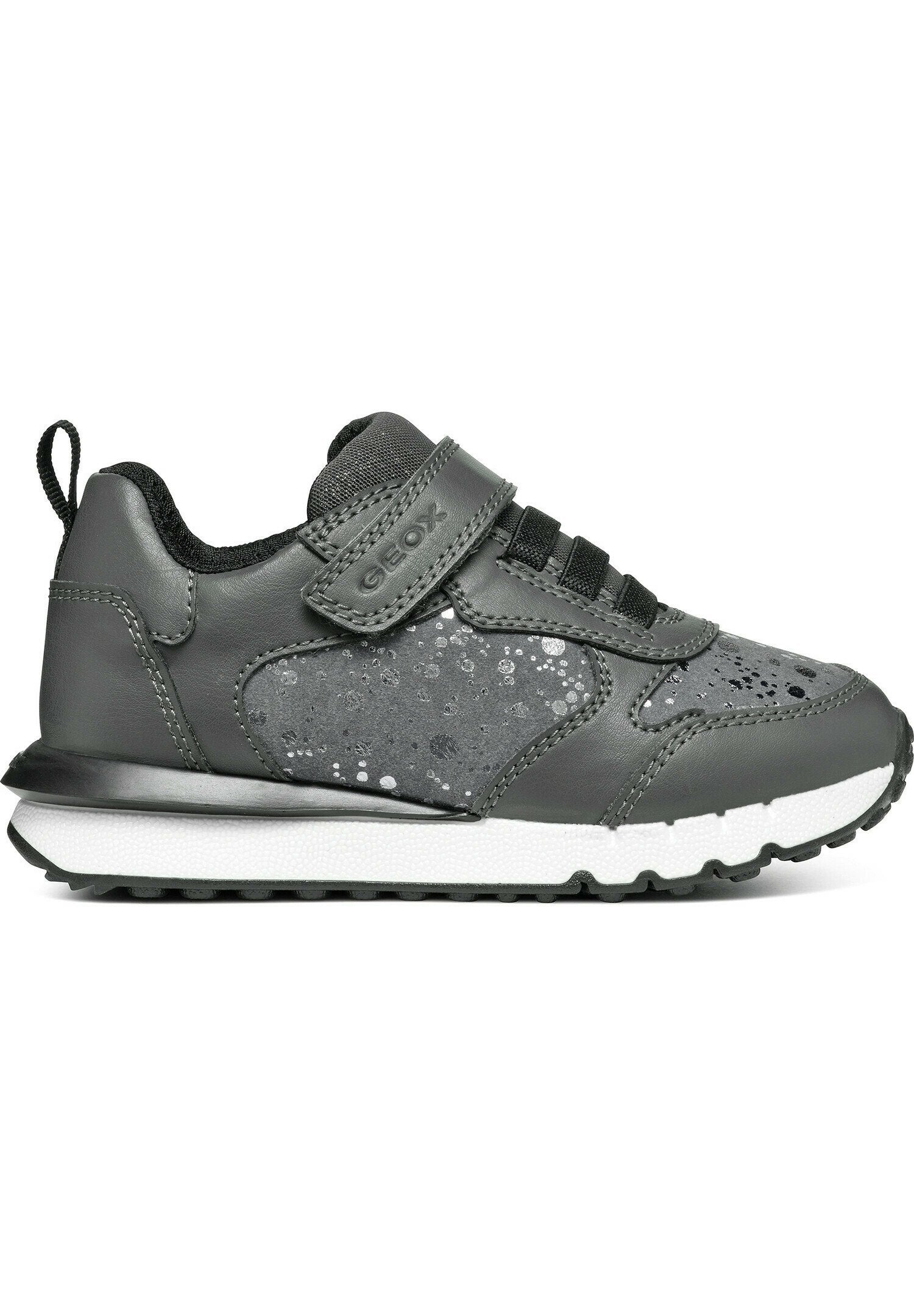 Graue Sneakers mit einem Obermaterial aus Leder, Netzdetails, elastischen Schnürsenkeln und einem Klettverschlussriemen. Sie besitzen eine strukturierte Gummisohle und dezente Akzente.