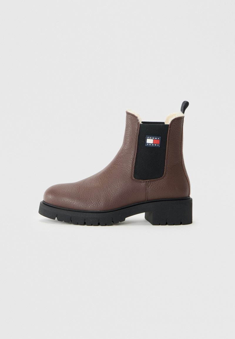 Braune Leder Chelsea-Boots mit schwarzem elastischem Seitenpanel, Schafwollfutter, klobiger schwarzer Sohle und Tommy Jeans-Logo-Patch an der Seite.