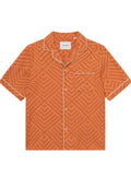 Kurzärmliges, oranges Shirt mit geometrischem Muster. Weiße Borte entlang des Kragens und der Tasche. Hergestellt aus leichtem Stoff.
