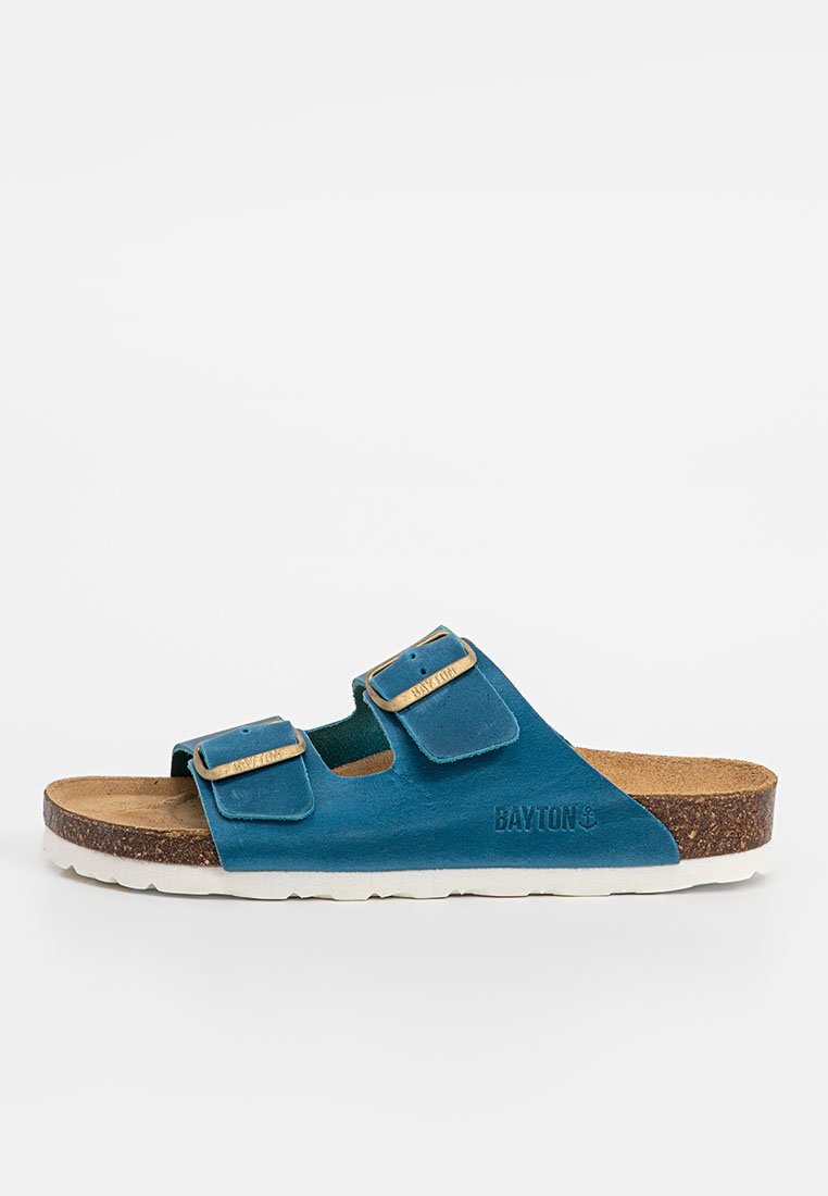 Teal Sandalen mit zwei verstellbaren Riemen, Korkfußbett und weißer Gummisohle. Mit eingraviertem Logo an der Seite.
