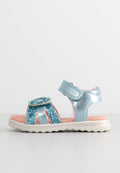 Hellblaue Sandalen mit Glitzerelementen, verstellbarem Riemen, rosa Innensohle und weißer strukturiertem Außensohle. Offene Zehenform für Atmungsaktivität.