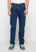 Dunkelblaue Jeans aus Denim mit geradem Bein, fünf Taschen und kontrastierenden Nähten. Kombiniert mit grünen Turnschuhen mit weißen Schnürsenkeln.