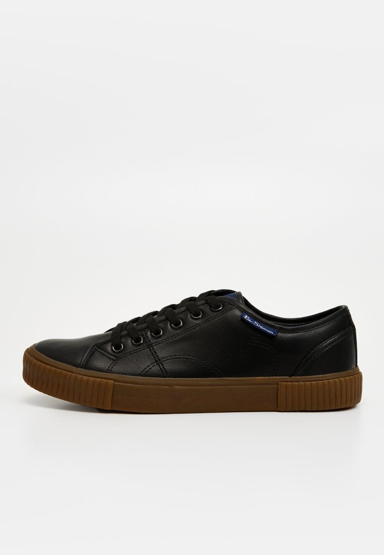 Schwarze Leder-Sneaker mit flachen Schnürsenkeln, runder Zehenpartie und strukturiertem braunem Gummisohle. Verfügt über ein blaues Logo-Tag an der Seite.