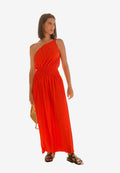 Ein einseitig geschultertes, orangefarbenes, plissiertes Maxikleid mit gerafftem Taillenbund; glatte Textur; kombiniert mit flachen, schwarzen Sandalen und einer geflochtenen goldenen Handtasche.