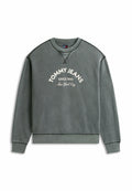 Grauer Sweatshirt mit Rundhalsausschnitt und weißem Text "TOMMY JEANS SINCE 1985 New York City" auf der Vorderseite sowie dunklen Kontrastnähten an Nähten und Bündchen.