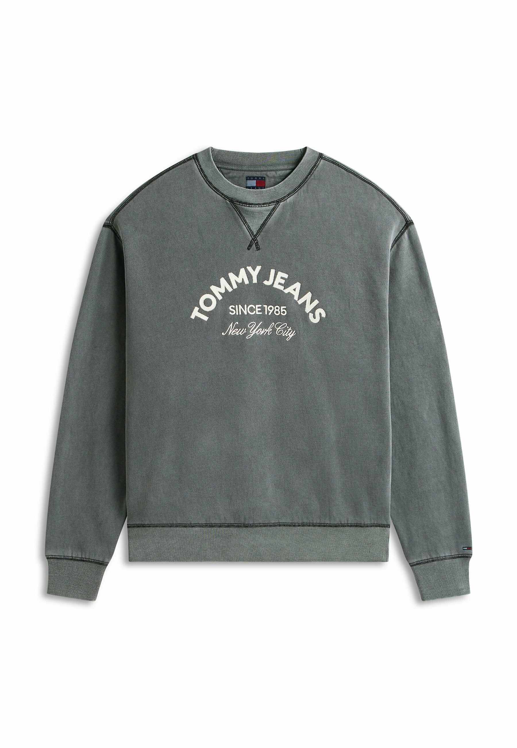 Grauer Sweatshirt mit Rundhalsausschnitt und weißem Text "TOMMY JEANS SINCE 1985 New York City" auf der Vorderseite sowie dunklen Kontrastnähten an Nähten und Bündchen.