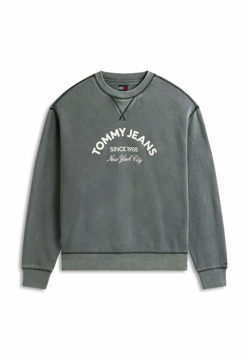 Grauer Sweatshirt mit Rundhalsausschnitt und weißem Text "TOMMY JEANS SINCE 1985 New York City" auf der Vorderseite sowie dunklen Kontrastnähten an Nähten und Bündchen.
