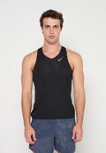 Junger Mann trägt ein schwarzes ärmelloses sportliches Tanktop mit goldenem Nike-Logo und blaue Sportshorts und steht vor einem einfarbigen Hintergrund.