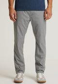 Graue Chino-Hosen mit glatter Textur, schmalem Schnitt und subtilen Stickdetails, kombiniert mit hellgrauen und weißen Sneakers.