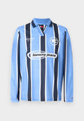 Langärmliges Poloshirt in Hellblau mit dunkelblauen vertikalen Streifen, mit V-Ausschnitt, weißen Akzenten und "Tommy Jeans" Logo auf der Brust.